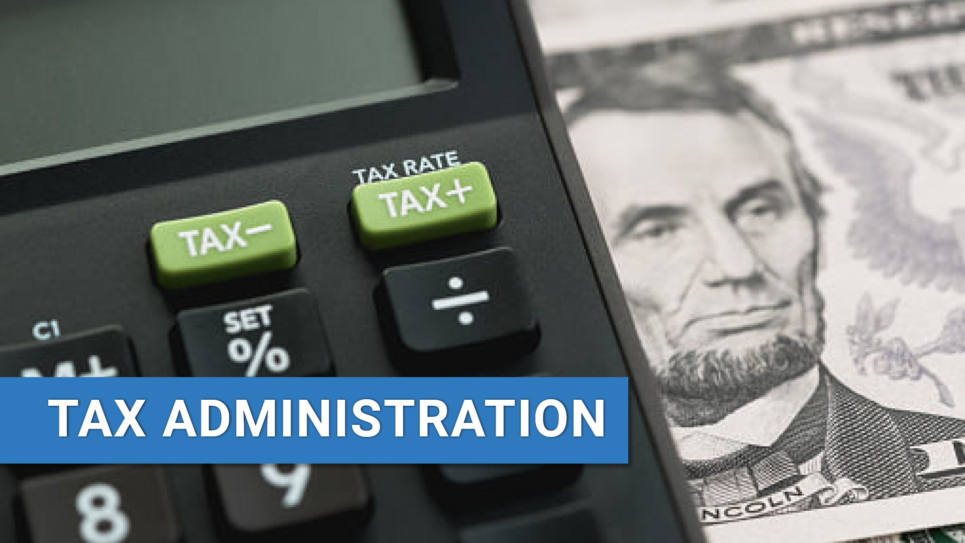 Close up of calculator over a five dollar bill with text: Tax Administration.