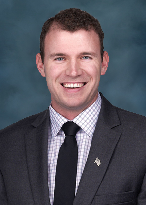 Board of Health member Dakota Wright, smiling in front of a blue background